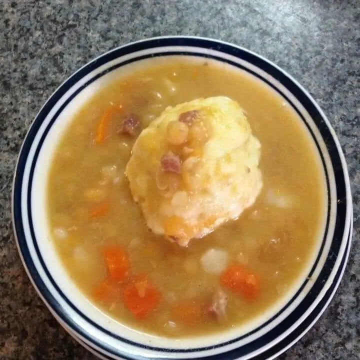 A bowl of soup topped with a dumpling
